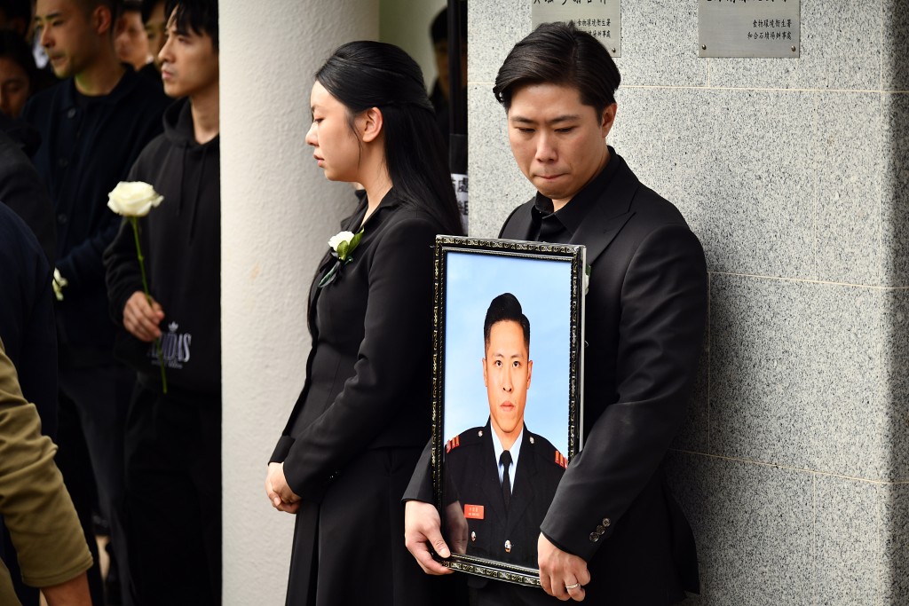 偉豪親屬捧着遺照，未婚妻一臉哀傷。