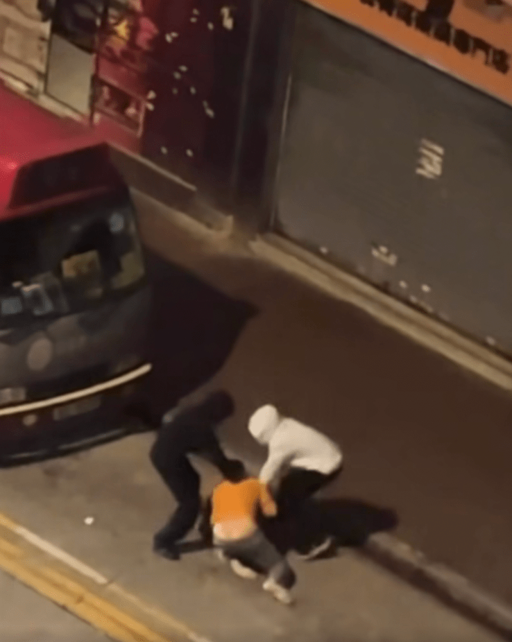 黑衣男子趁勢想搶走事主的斜孭袋,但事主死命抓緊不放,雙方在馬路上拉扯角力。fb「車cam L(香港群組)」 黑衣男子趁勢想搶走事主的斜孭袋,但事主死命抓緊不放,雙方在馬路上拉扯角力。fb「車cam L(香港群組)」