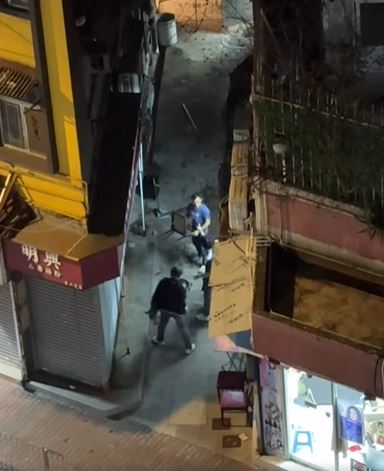 藍衫男與兩黑衫男對峙，有人擸凳攻擊。FB香港突發事故報料區及討論區 Becky Cohen影片截圖