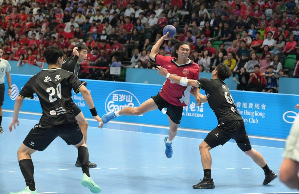 香港手球隊（紅衫)在銅牌戰力戰上屆亞軍的北京隊（黑衫)。何君健攝