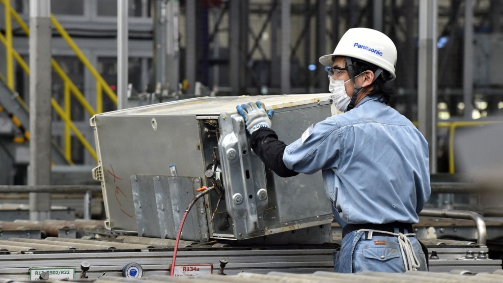 茨城縣稲敷市的Panasonic松下回收廠工人拆卸壓縮機。 法新社