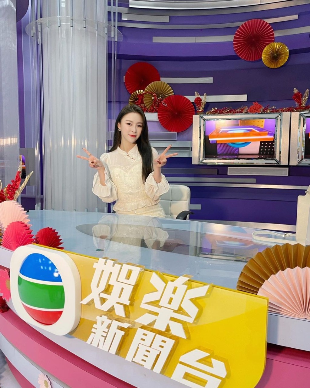 庄锭欣坐在TVB娱乐新闻台厂景前拍照。