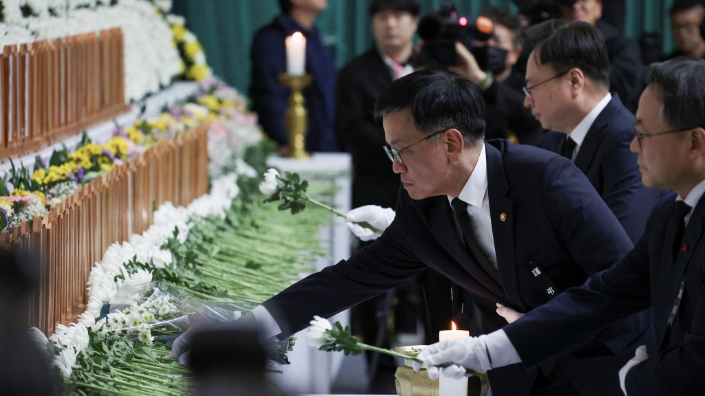  南韓代理總統崔相穆到務安體育公園獻花致意。 路透社