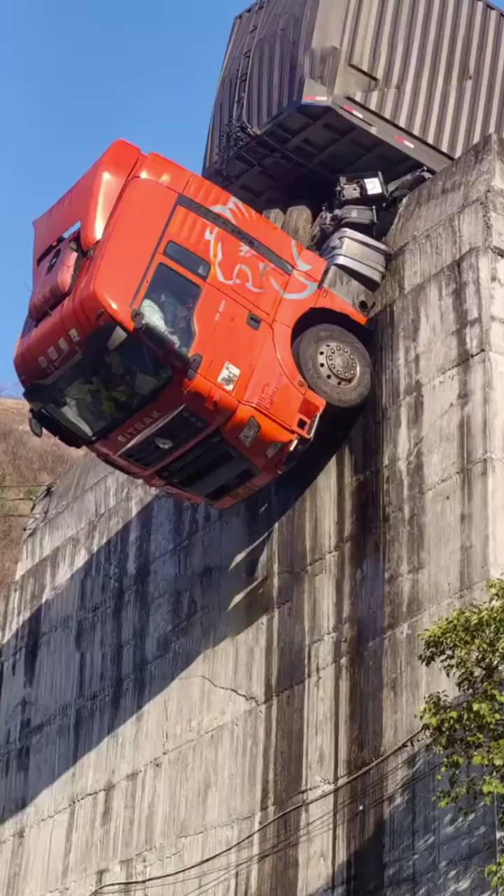 貨櫃車衝出公路，拖頭90°懸掛半空。陝西消防