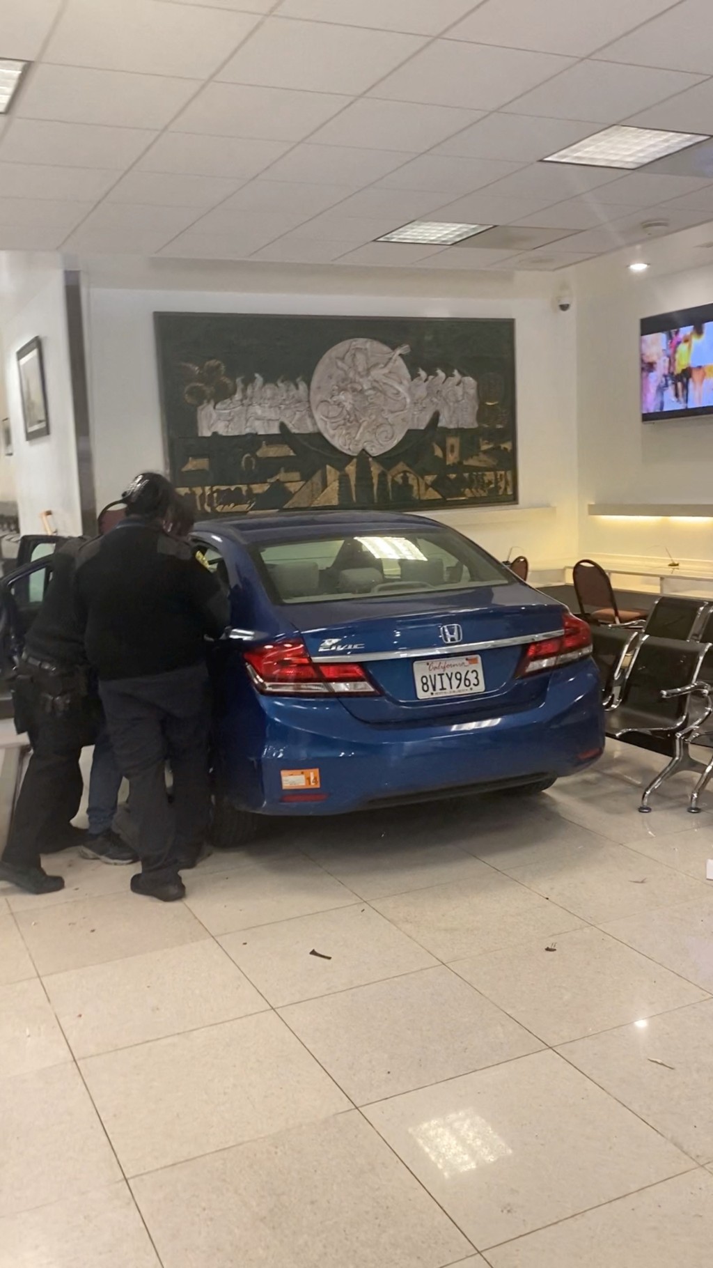 撞入中國總領事館領事館證件大廳的藍色私家車。路透社