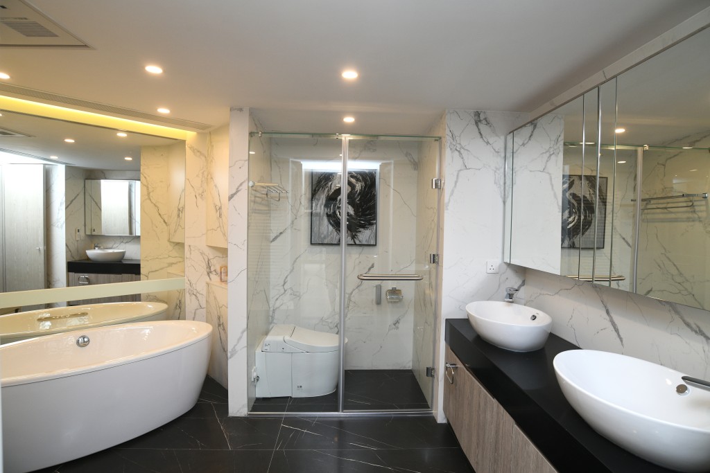 浴室以明亮大理石铺设，提供独立浴缸及淋浴间等设备。