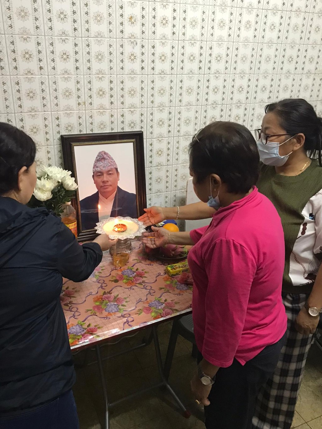 妻子以及亲友在家中为意外惨死的尼泊尔钉板科文进行悼念仪式。