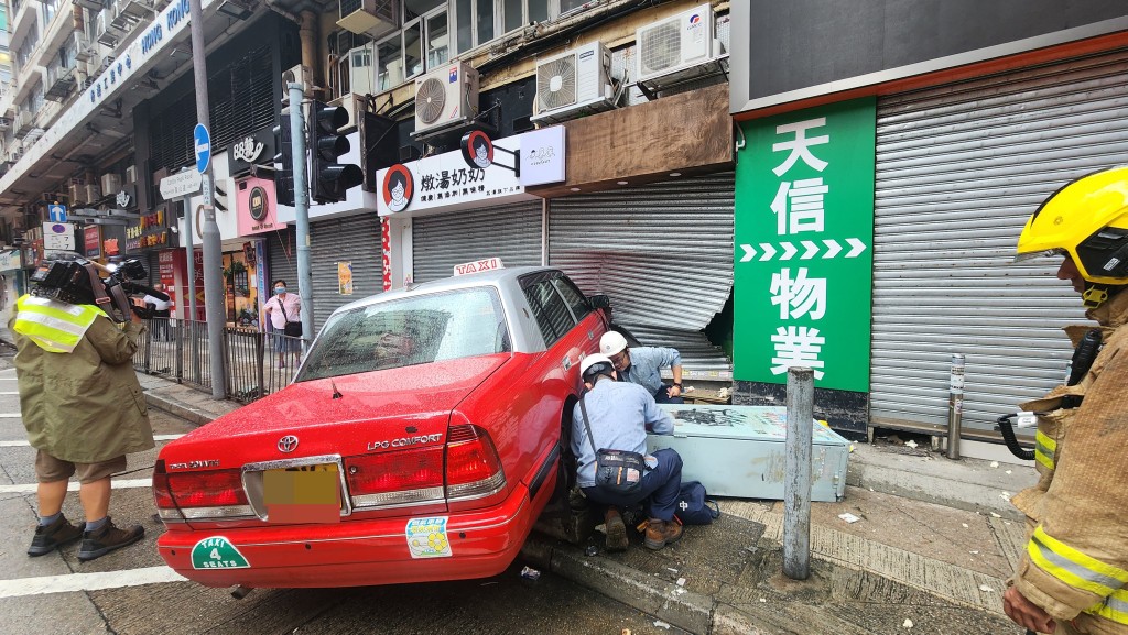 的士撞毀路邊一個電箱，電力公司職員正進行檢查。黎志偉攝