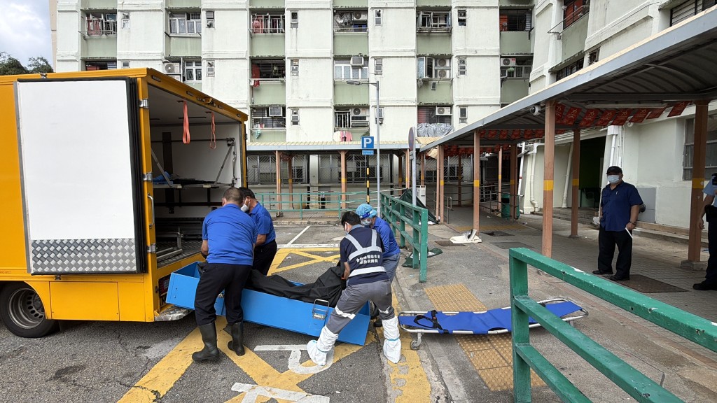 仵工移走男死者遺體。 仵工移走男死者遺體。