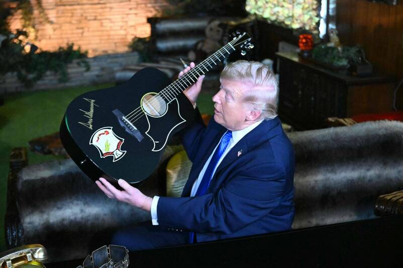 特朗普前往猫王故居参观，为复制品吉他签名时，特别小心，还要求试笔。法新社