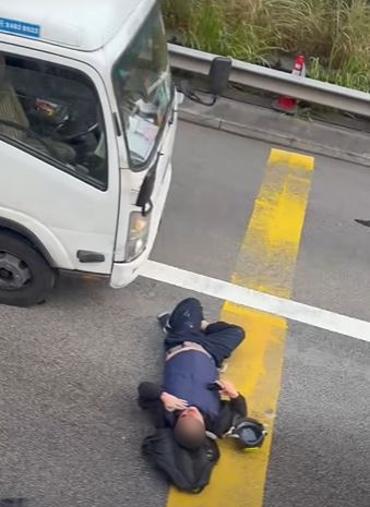 鐵騎士口鼻淌血倒臥貨車車頭前方。FB國滴網片截圖