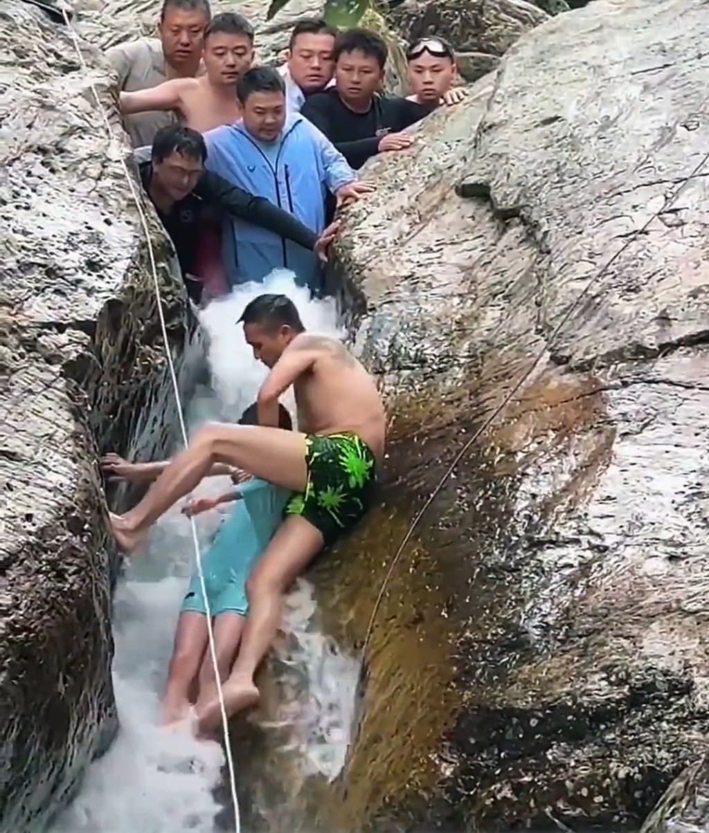男子終於拉出被困石縫的男孩。 男子終於拉出被困石縫的男孩。