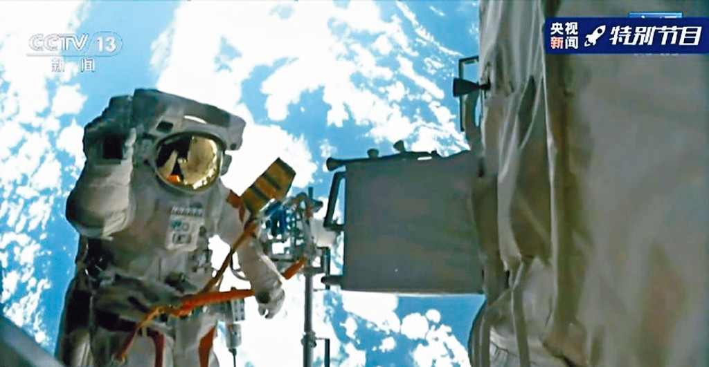 ■聂海胜站在机械臂上，背景是地球。