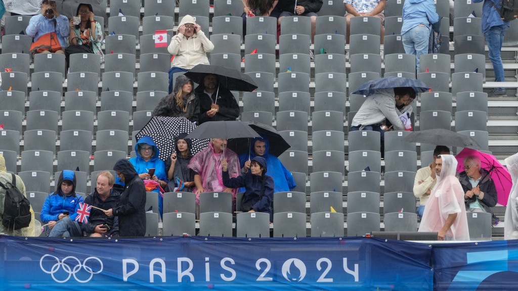 觀眾冒雨觀看巴黎奧運開幕式。 美聯社