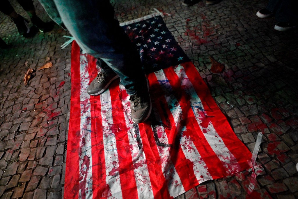 示威者践踏美国旗。法新社