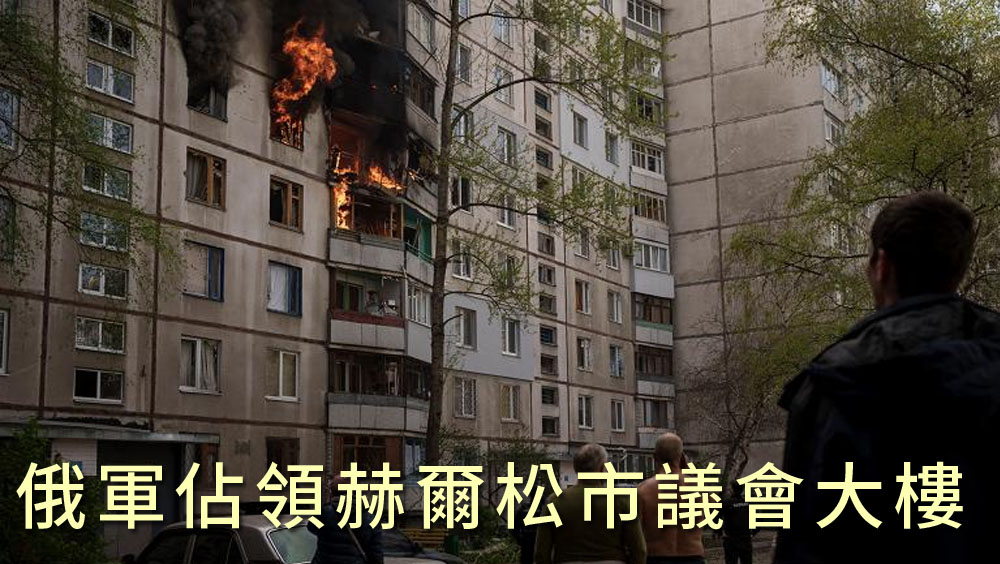 俄軍轟炸烏克蘭哈爾科夫後，民眾看著一棟住宅樓被燒毀。AP圖