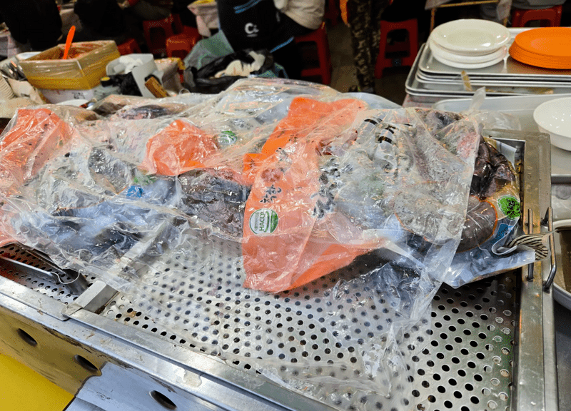 网民发现南韩节庆小食档将血肠连胶袋包装放在蒸炉上。 Threads