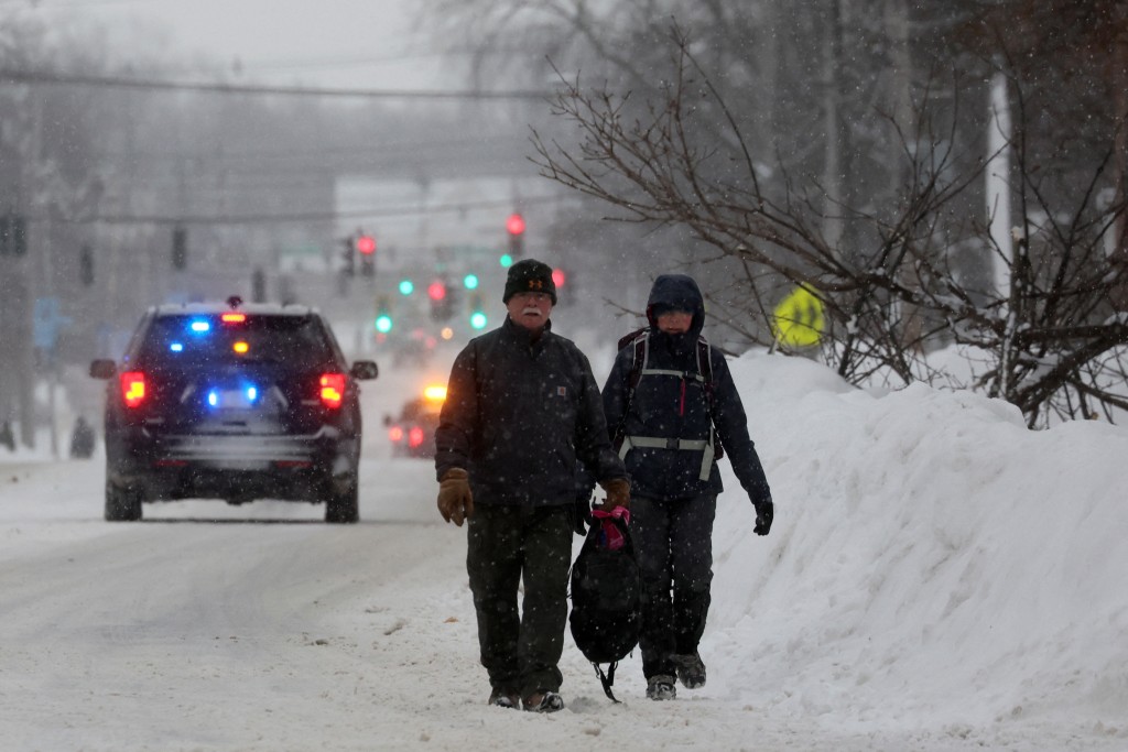 市民在雪中前行。路透社