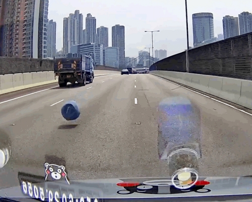 一輛夾斗車於公路行駛時，突然掉出1個膠桶，幸後方司機及時閃避。影片截圖