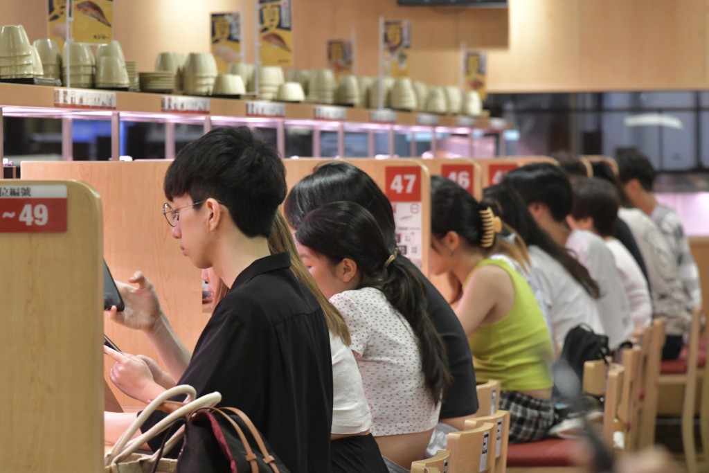 連鎖壽司店仍有不少食客光顧外輪候入座。禇樂琪攝