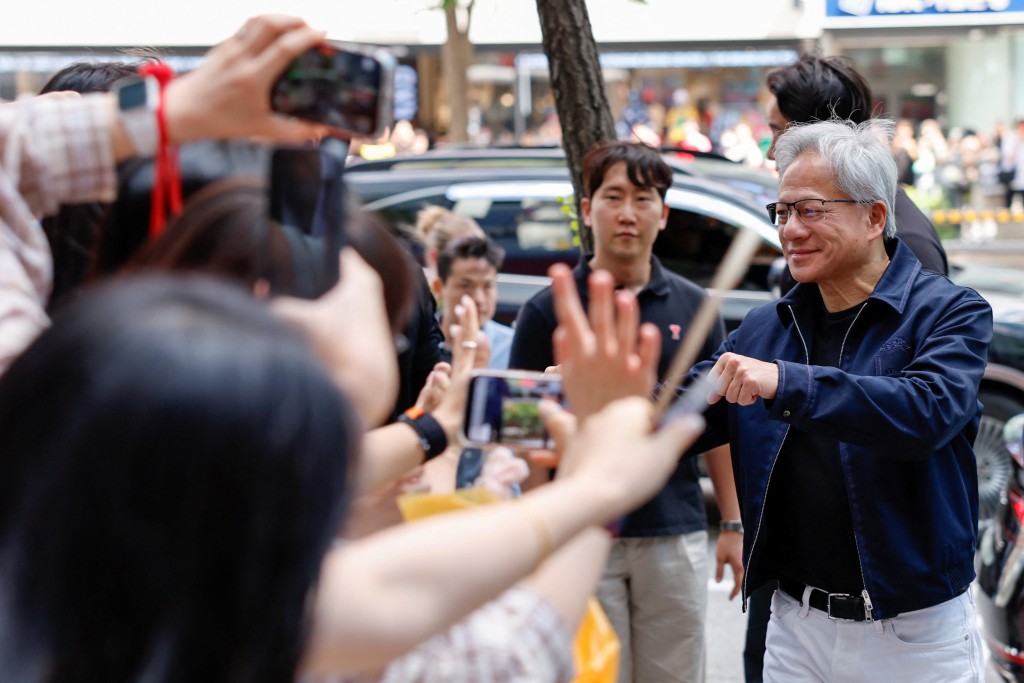 黃仁勛在韓國首爾一間網吧前與粉絲擊拳。路透社