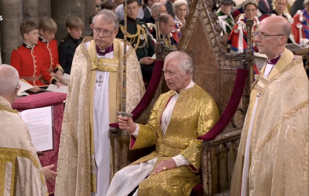 查理斯坐上「加冕椅」，并接受皇权之物。