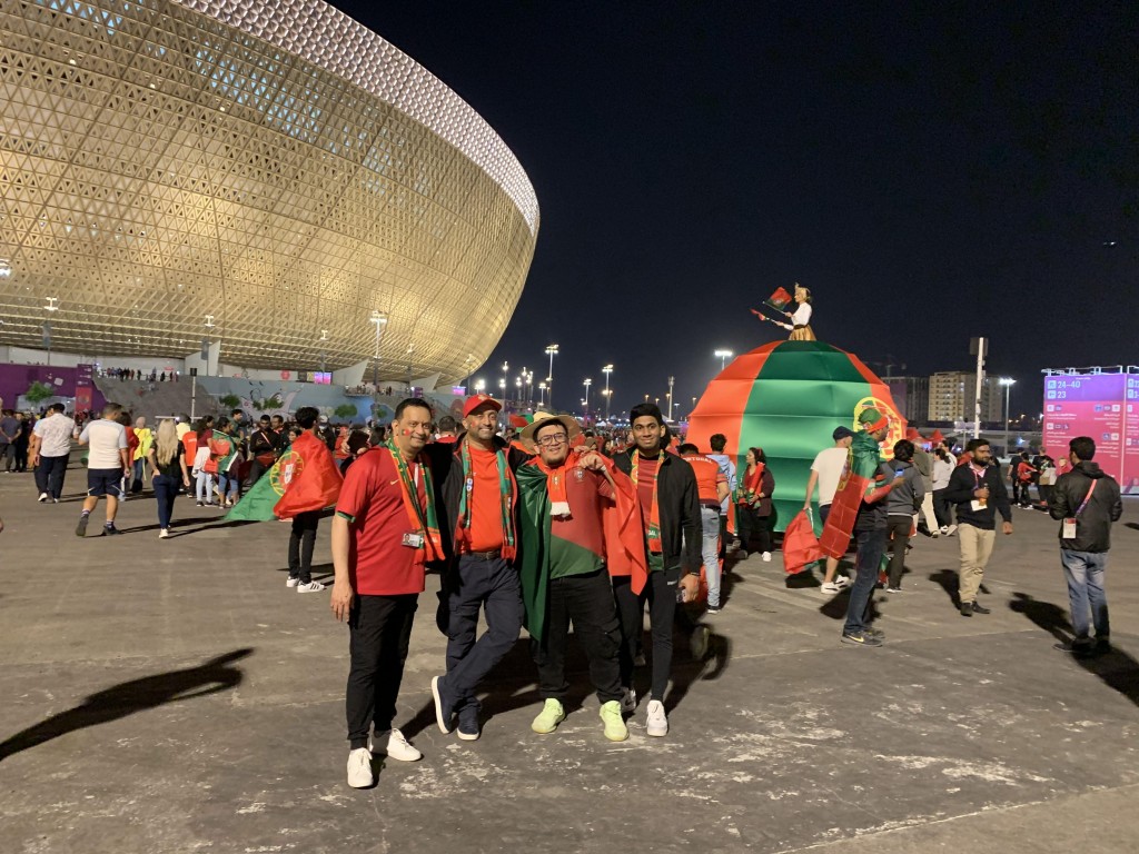 葡萄牙球迷在外形像金飯碗的球場外合照。