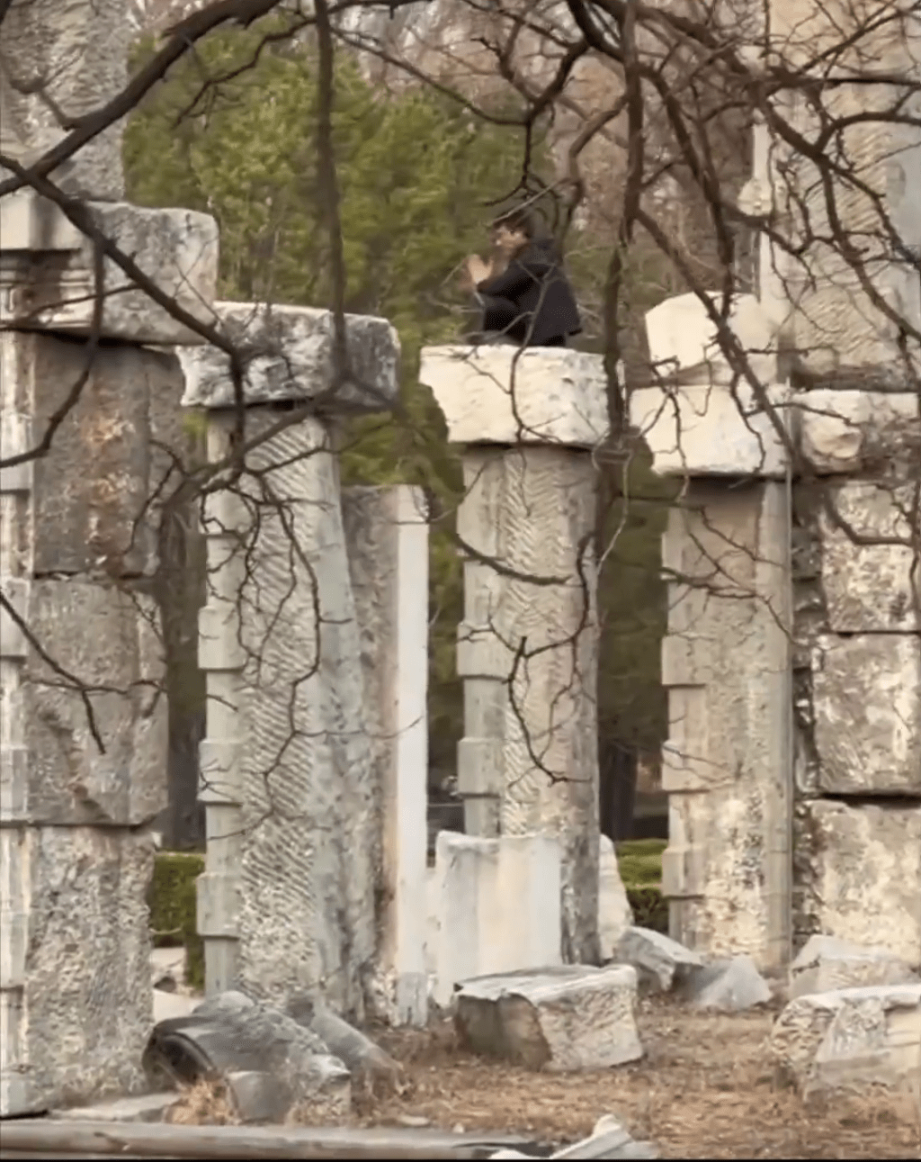 男子爬上遺址建築後坐下。