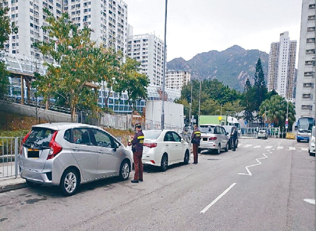 屯門警區打擊違例泊車，向涉嫌違泊車輛發出罰款通知書。