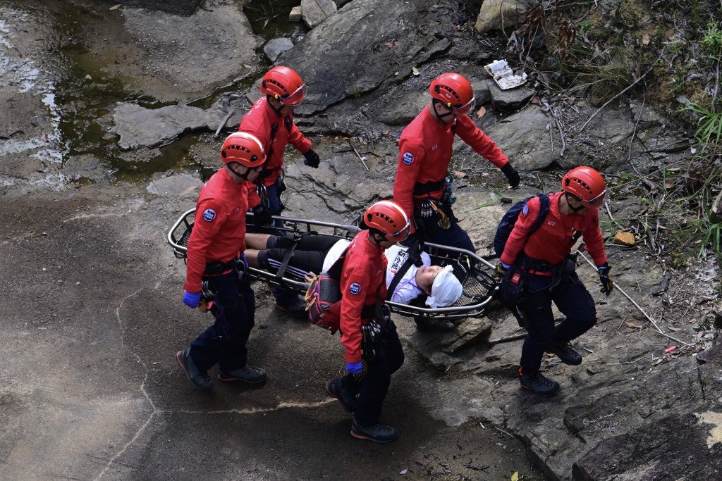 演习中，民安队在香港仔下水塘一带，游绳落水坝拯救一名昏迷女子。陈极彰摄