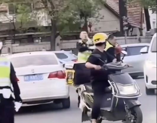 天津两名交警无视车来车往，在街道中央互殴。