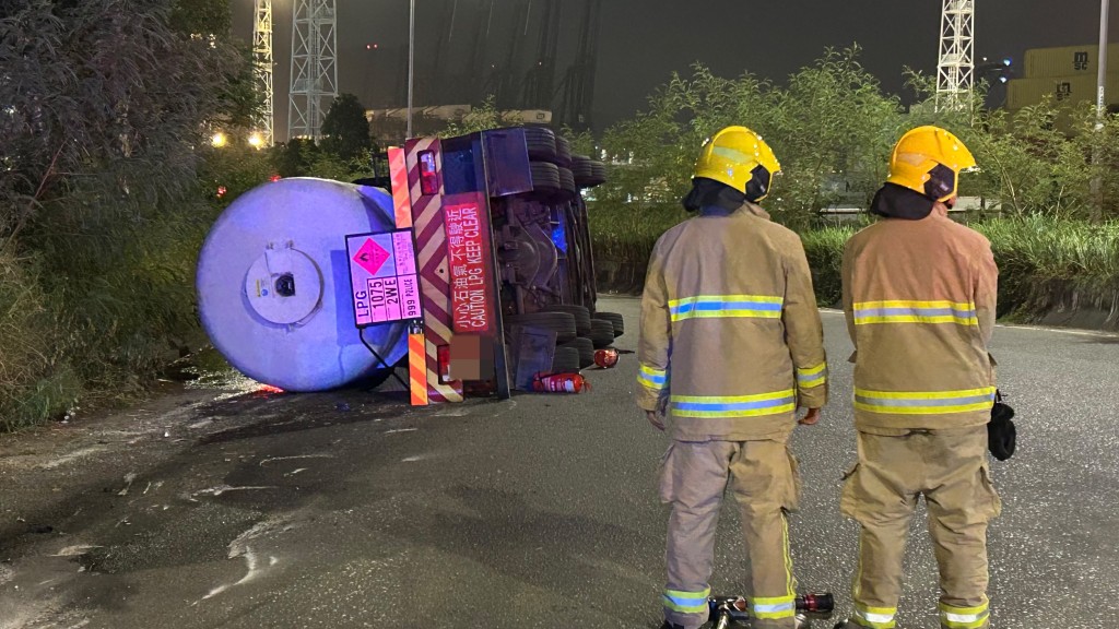 青衣航運路一輛載有8噸石油氣汽缸車翻側，司機乘客一度被困，消防員現場戒備。蔡楚輝攝