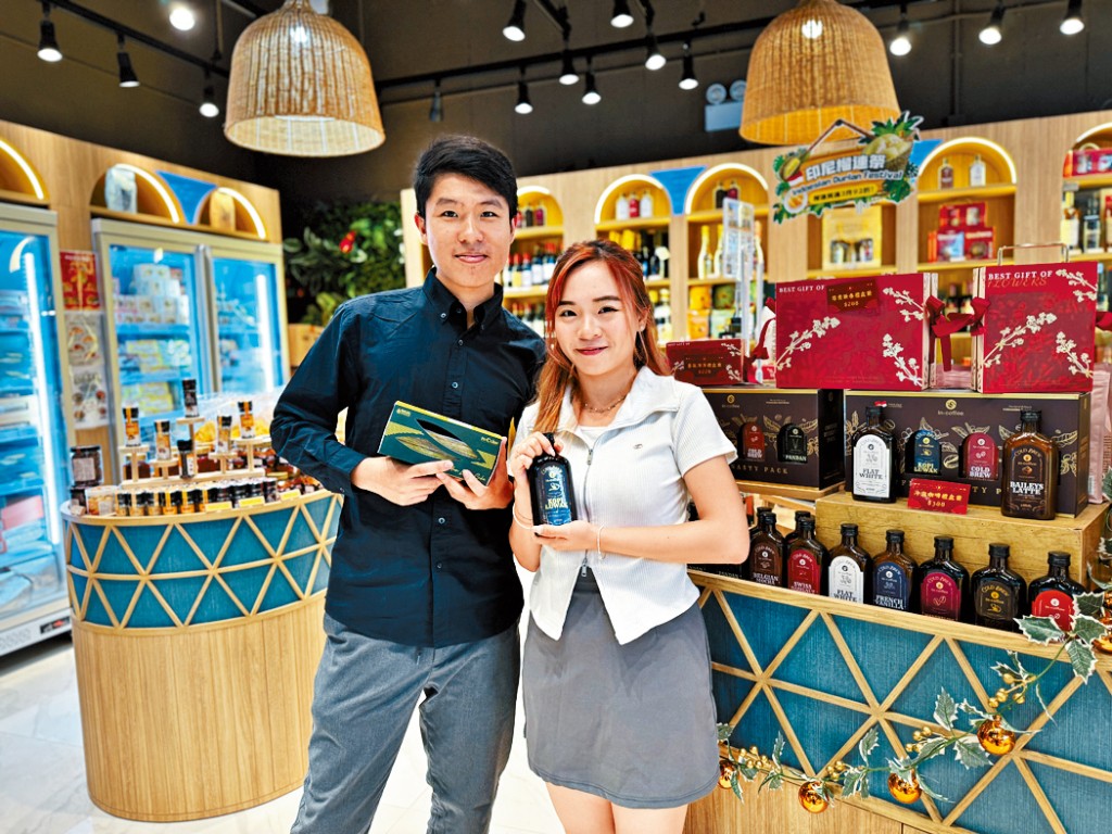 (左起)In-Mart創辦人葉焯然(Mark)與劉寶婷(Bobo),於啟德零售館的實體店,展示招牌產品,包括印尼千層蛋糕以及瓶裝印尼咖啡。
