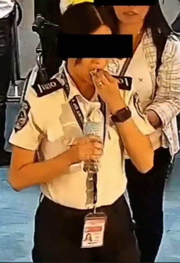 菲律宾的机场女安检狼吞虎咽吞美金灭证。影片截图
