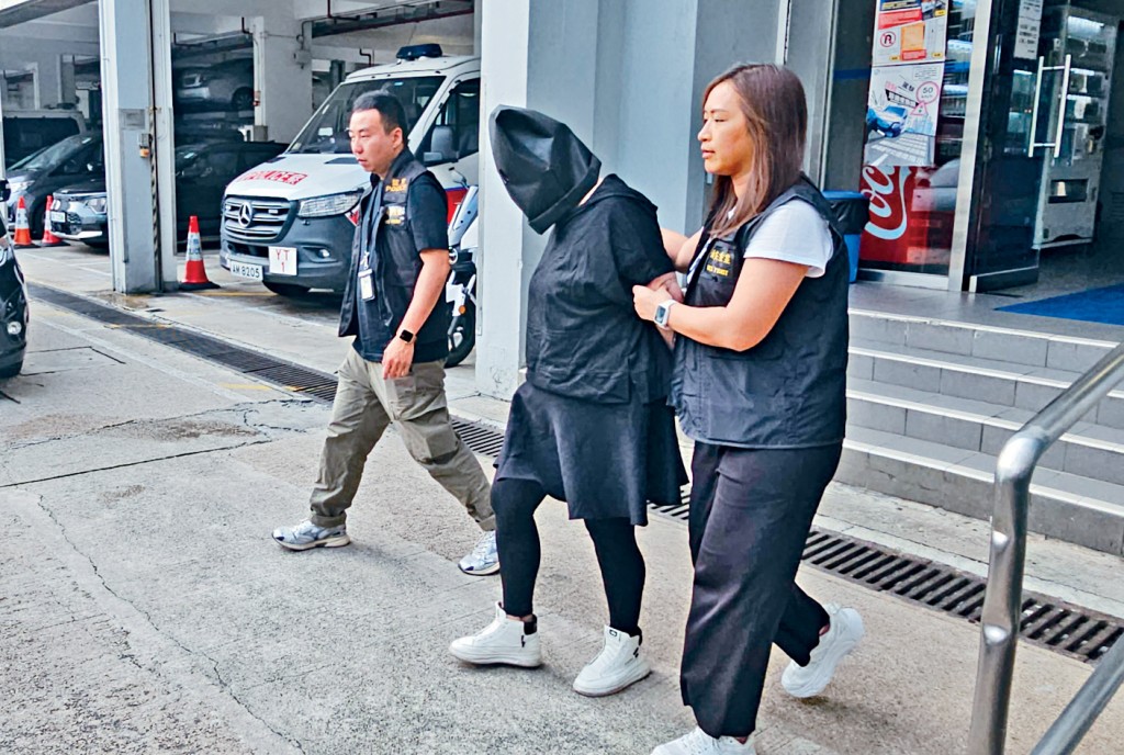 被捕女疑犯由探員押走。
