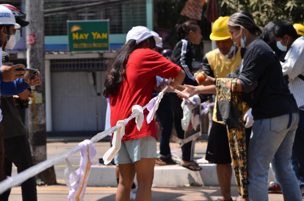 示威者前面掛起傳統女性筒裙。網圖