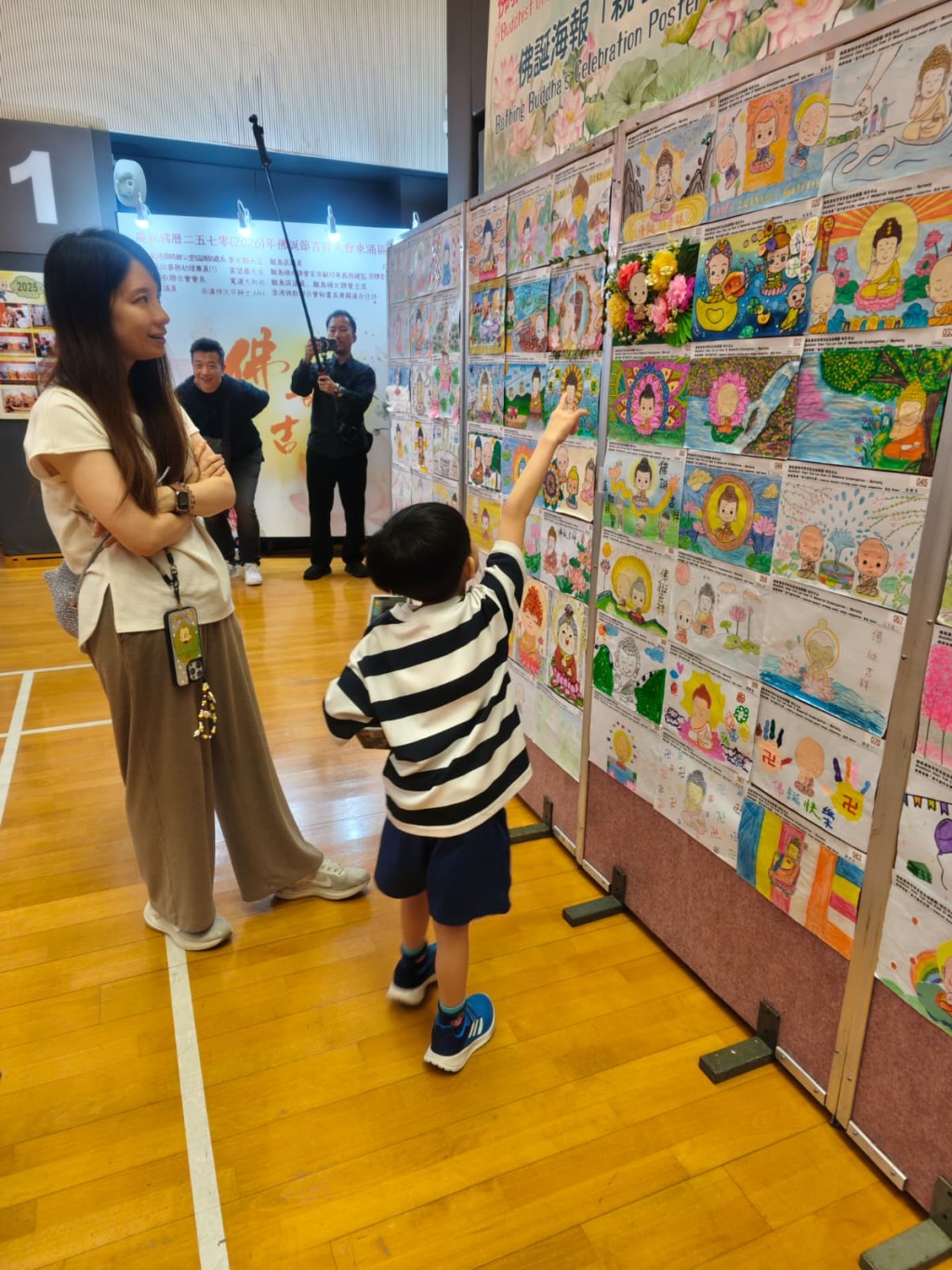 有家長與子女一同欣賞學生畫作。