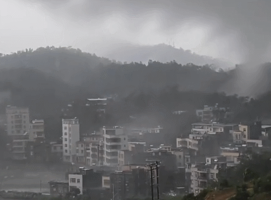 龍捲風橫掃廣東茂名,在山頭之間「舞動」並發出火光。