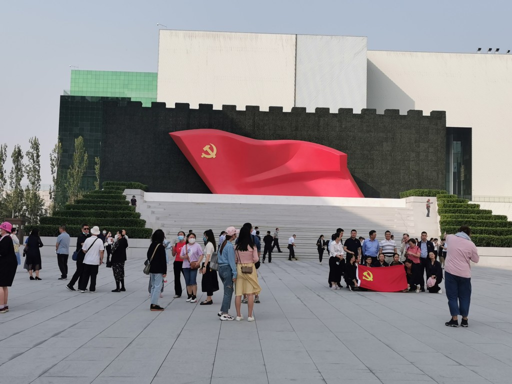 参观者在大型党旗雕塑《旗帜》前拍照。张言天摄
