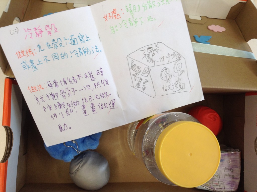 Jasmine展示學校與小朋友製作其 中一款管理情 緒工具「冷靜骰」：當自覺情 緒不穩便擲骰 一次，然後做 不同活動，如 繪畫、做運動 等平伏心情。（受訪者提供）