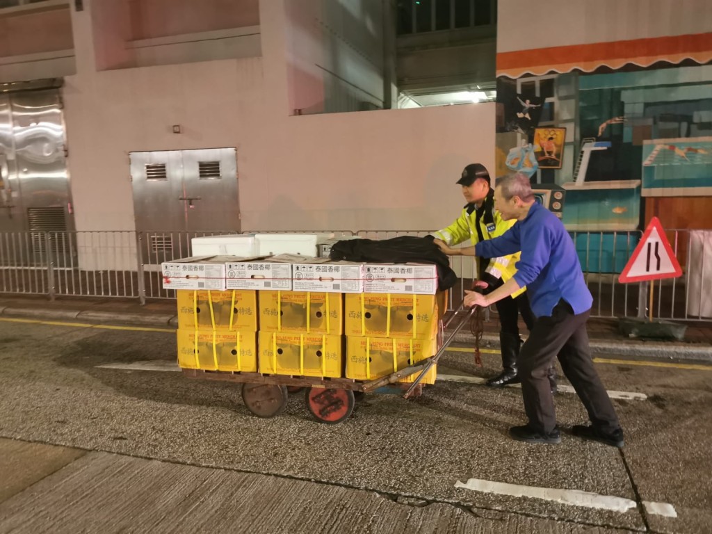 樂於幫助市民的警員關偉文協助長者推動手推車。