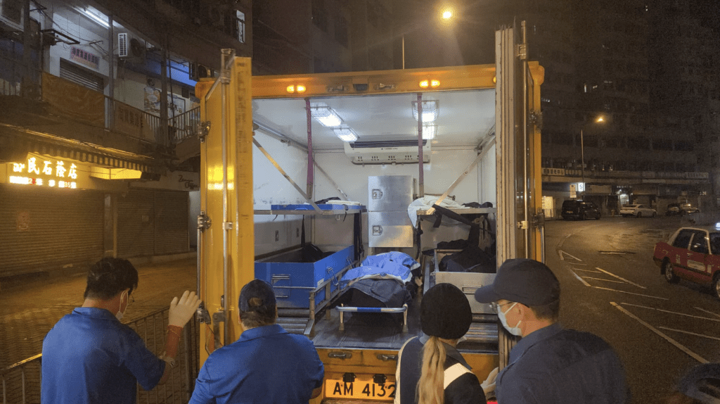 仵工舁走两具遗体。
