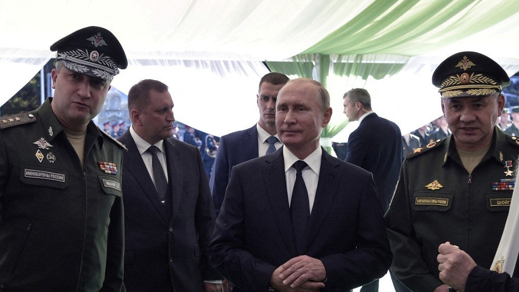 2018年，國防部副部長伊萬諾夫（Timur Ivanov，左）向普京（中）和紹伊古（右）一同出席活動。 路透社