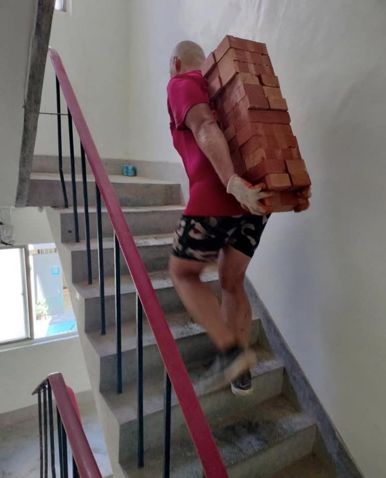 有网友上载一张男子背砖上楼梯的相片。网图