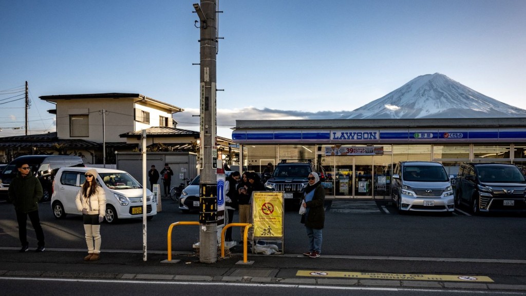 LAWSON便利店因攝影角度與富士山峰美景融為一體，成為熱門拍照打卡景點，觀光亂象叢生。法新社