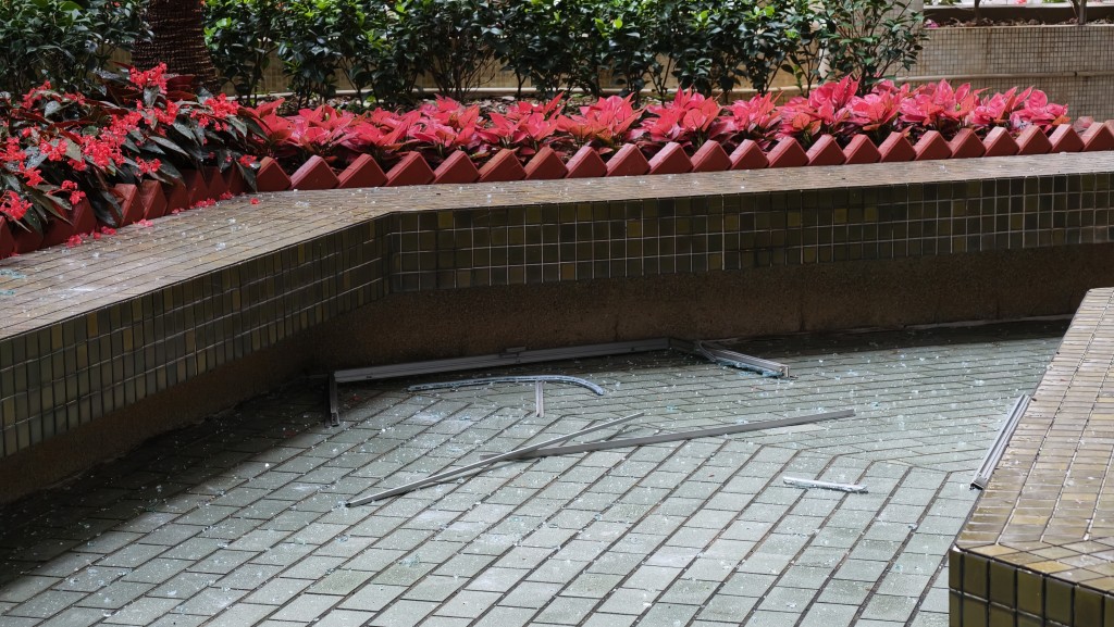 現場遍地玻璃碎及窗框殘骸。