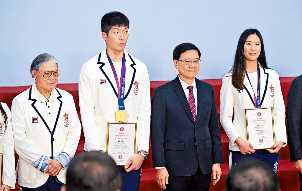 李家超(右二)向在亞運中獲獎的運動員頒發表揚狀。左二及右一為劍擊運動員張家朗與陳渭泠、左一為奧委會會長霍震霆。