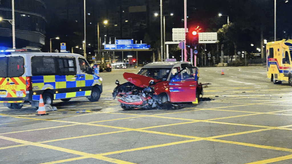 衝燈的士被撞後,車頭損毀嚴重,車尾亦被撞至變形,橫亙在十字路口中間。蔡楚輝攝 衝燈的士被撞後,車頭損毀嚴重,車尾亦被撞至變形,橫亙在十字路口中間。蔡楚輝攝