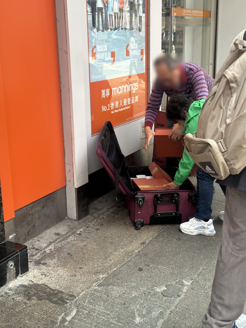 一對男女旅客在店鋪門外整理行李箱