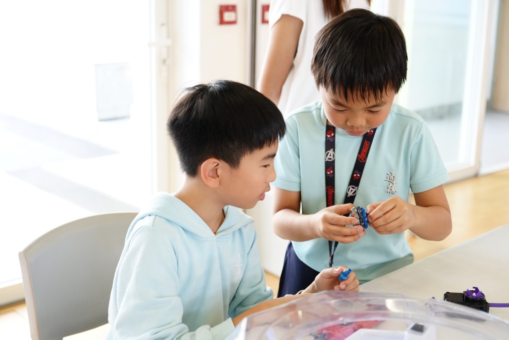 當潮流玩具走入常規課室,能有效驅動學生的自主學習動機,自發地在戰鬥盤邊進行科學探究。(圖片來源:受訪者提供) 當潮流玩具走入常規課室,能有效驅動學生的自主學習動機,自發地在戰鬥盤邊進行科學探究。(圖片來源:受訪者提供)